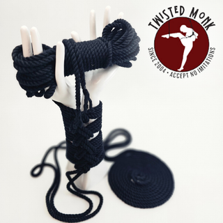 Black hand-spun bamboo rope coiled on a display hand by The Twisted Monk for creative projects
