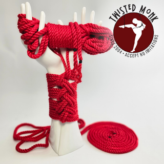 Hand-spun bamboo bondage rope by The Twisted Monk displayed on a sculpted hand in vibrant red
