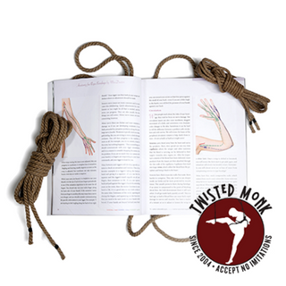Open book on bondage techniques for all bodies next to two lengths of rope for practical use