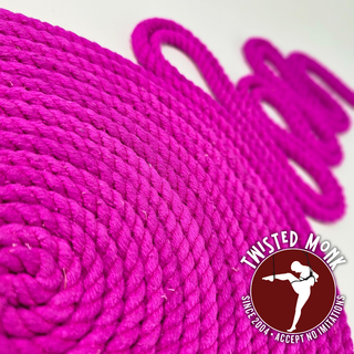 Close-up of UV-reactive silk bondage rope in vibrant pink color, spiraled for easy use