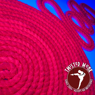 Bright pink UV-reactive silk bondage rope coiled on a blue background by The Twisted Monk
