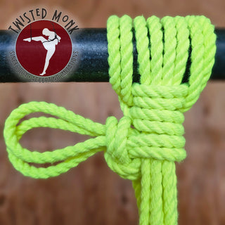 UV yellow bondage rope tied in a secure knot on a black pole for versatile use