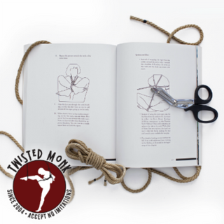 Seductive Art of Japanese Bondage book pages with illustrations and scissors on a table