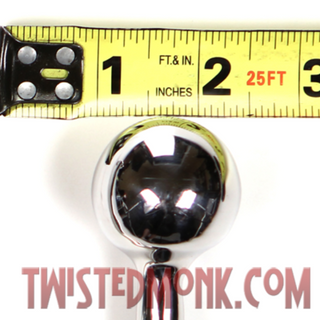 Measuring tape placed next to a chrome Z-Hook bondage accessory for size reference